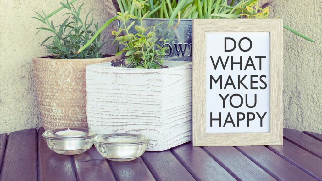 Green plants in a beautiful arrangement together with a framed picture that says "Do what makes you happy"