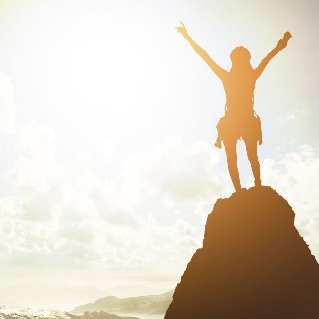 Smiling woman looking toward sunrise, symbolizing self-worth and new beginnings.