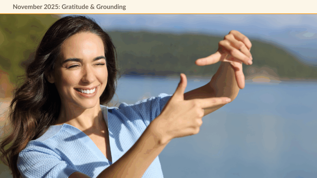 Smiling woman standing on a coastline squinting and making a fram with her hands symbolizing choosing a happy perspective.